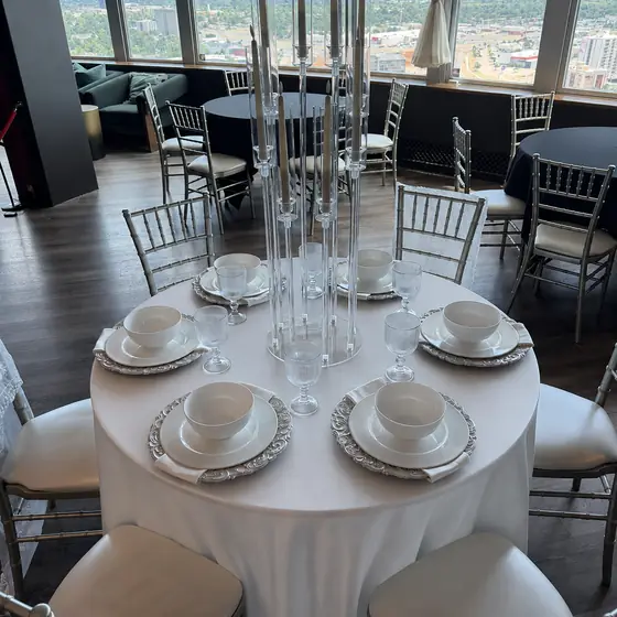 Ivory tablecloth set for six with candelabra over the Oklahoma City skyline